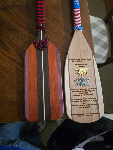 Two customized wooden paddles with paracord made by Mostad Works in San Diego