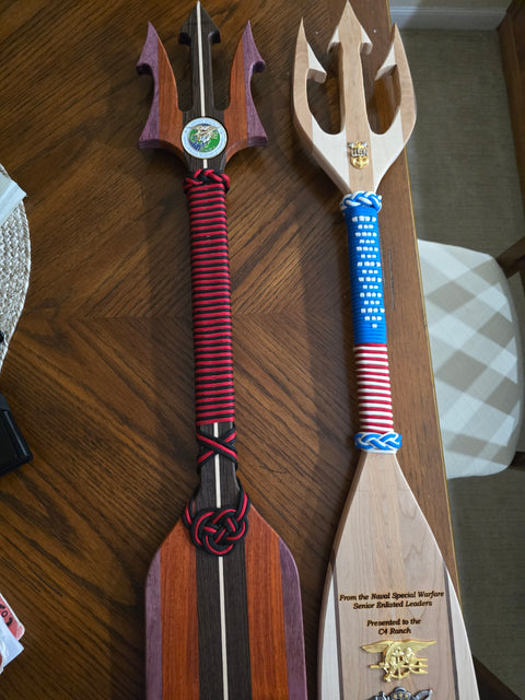 Two decorative paddles with unique handles on a wooden surface made for the Navy as gifts in San Diego